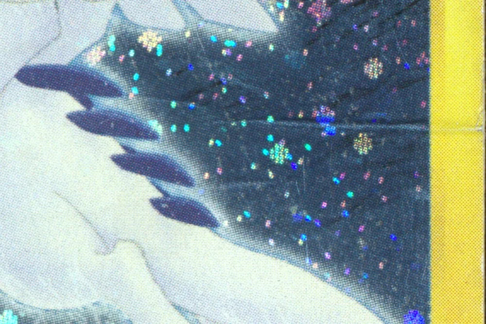 Close-up of the front of the water-damaged Crystal Lugia: creases running through the holo and fine scratching across the artwork